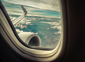 Fototapeta premium Beautiful view from porthole of airplane on sky with clouds und