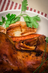 Festive baked duck with apples close-up on a plate on a table.