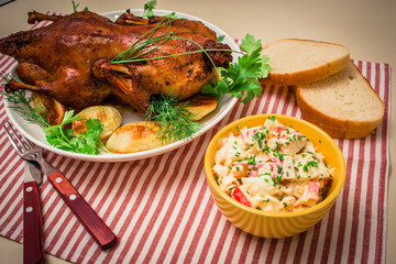Festive baked duck with apples close-up on a plate on a table.