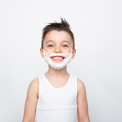 Smiling boy with shaving foam on face
