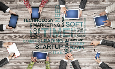 Top view of businesspeople sitting at table and using gadgets