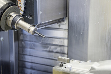 The 5-axis CNC  milling machine  tapping the automotive part with the tapping tool.Hi-technology machining concept.