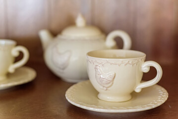 Teapot and cups of tea with chicken image in cafe