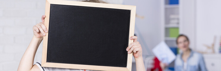 Child holding a blackboard