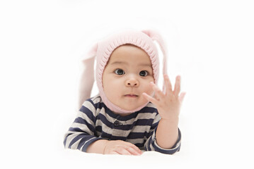 Cute Asian baby girl with rabbit hat showing her fingers on white background