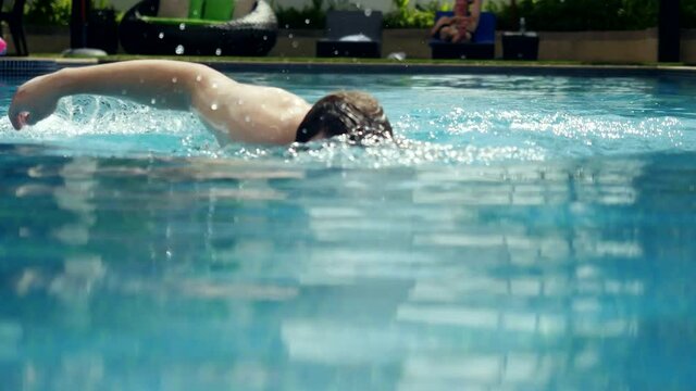 Young man swims in a swimming pool. 3840x2160