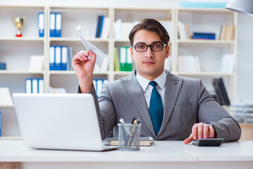 Businessman with paper airplane in office