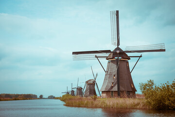 Traditional Dutch windmills on a canal bank in Nethelands vintage color toned