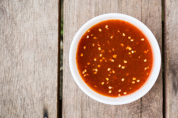 Sweet and Spicy chilly sauce over wooden background. Top view.