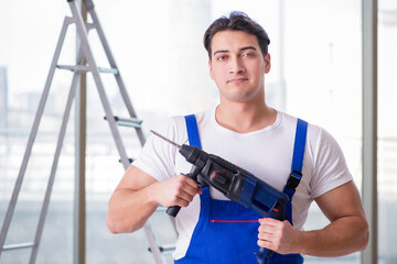 Young worker with hand drill