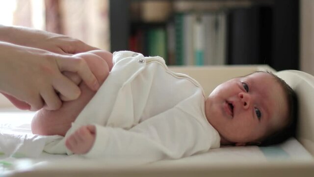 Mother is bending baby&rsquo;s feet suffering from constipation