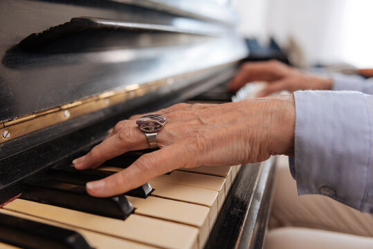 Female Hands Of Mature Woman Touching Piano