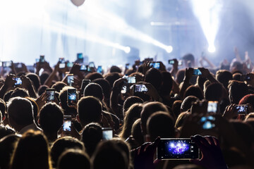 Hand with a smartphone records live music festival