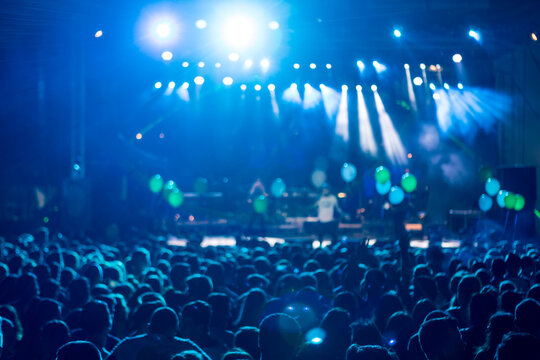 silhouettes of concert crowd in front of bright stage lights. motion image