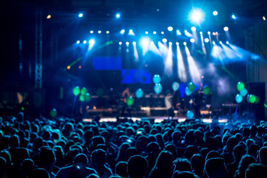 silhouettes of concert crowd in front of bright stage lights. motion image