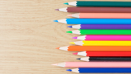 the colorful color pencils on the wooden table. copy space