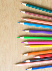 the colorful color pencils on the wooden table. copy space