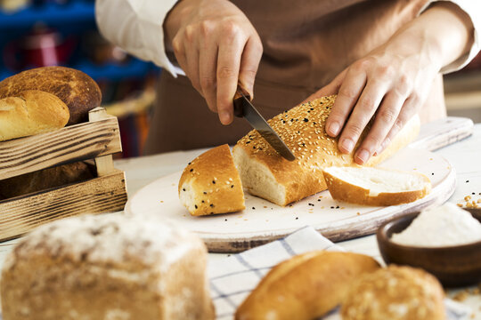 Female hands cutting freshly bread