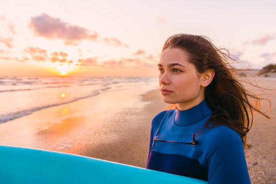 Sporty young surf girl with  at sunset or sunrise on ocean