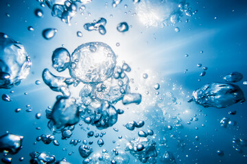 Bubbles and sun rays in underwater, in blue ocean.