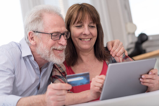 Mature Couple Shopping Online With Tablet And Credit Card