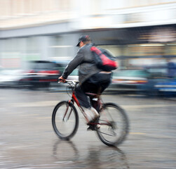 Cyclist on the city roadway in a rainy day