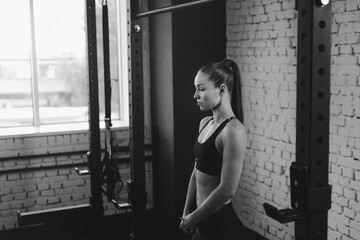 attractive sportswoman standing in sports center, black and white