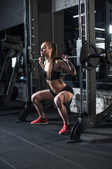 Fototapeta na wymiar side view of sportive woman lifting barbell at gym