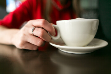 young women sitting and drinking coffee at cafe restaurant. a cup with coffee is on table. hand of woman. people in love