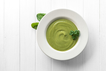 Creamy spinach soup with spinach on side, topview