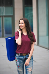 Beautiful happy girl goes shopping in the city.