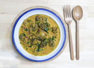 Cockle curry bowl with wood spoon and fork