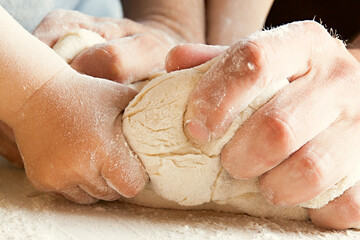 Fototapeta premium The son and father knead the dough.