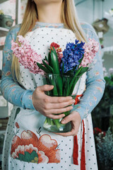 woman florist holding bouquet of hyacinth indoor in flower shop. close up