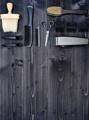 Hairdresser tools on wooden background. Top view on wooden table with scissors, comb, hairbrushes and hairclips, free space. Barbershop