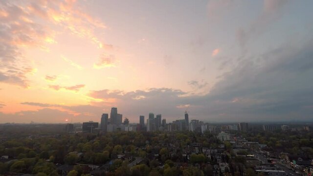 Toronto midtown sunset with beautiful clouds over residential area near of Eglinton Ave E, Yonge St and Mount Pleasant with highrise condo, apartment and office buildings, houses, and traffic.