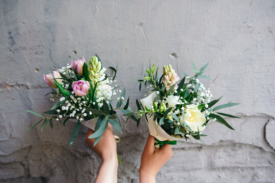 Two small bouquets of freesia, tulip and hyacinth flowers in a woman's hand