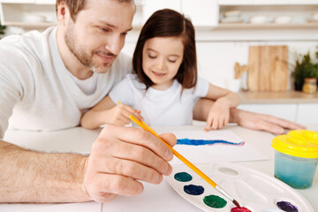 Smiling young father using watercolour palette