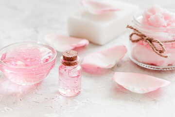 Obraz na płótnie Canvas body treatment with rose petals and cosmetic set white desk background