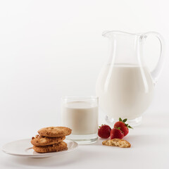 Close-up view of tasty homemade cookies with fresh milk and strawberries isolated on white