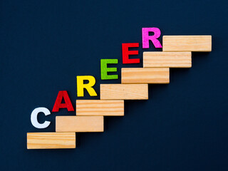 Wood block stacking as step stair with colorful of "CAREER" word on it in black background. Business concept for success process.