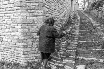 An elderly woman walking the streets of Vitsa in Zagori area, Northern Greece