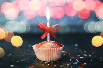 birthday cupcake with a candle bokeh