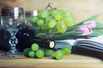 wooden table with wine bottle book and grape