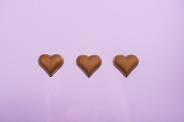 top view of heart shaped chocolate candies isolated on pink