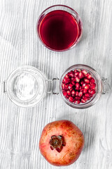 red pomegranate juice and sliced fruit on wooden background top view
