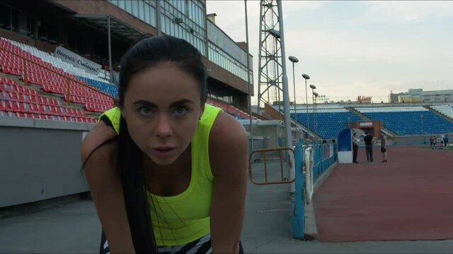 The girl regains breath after Jogging and looking at the camera