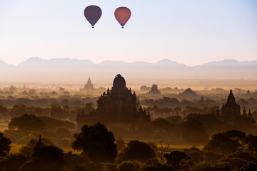 Fototapeta na wymiar Scenic sunrise with many hot air balloons above Bagan in Myanmar. Bagan is an ancient city with thousands of historic buddhist temples and stupas.