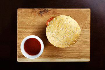 burger with sauce on a wooden board
