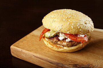 burger with sauce on a wooden board